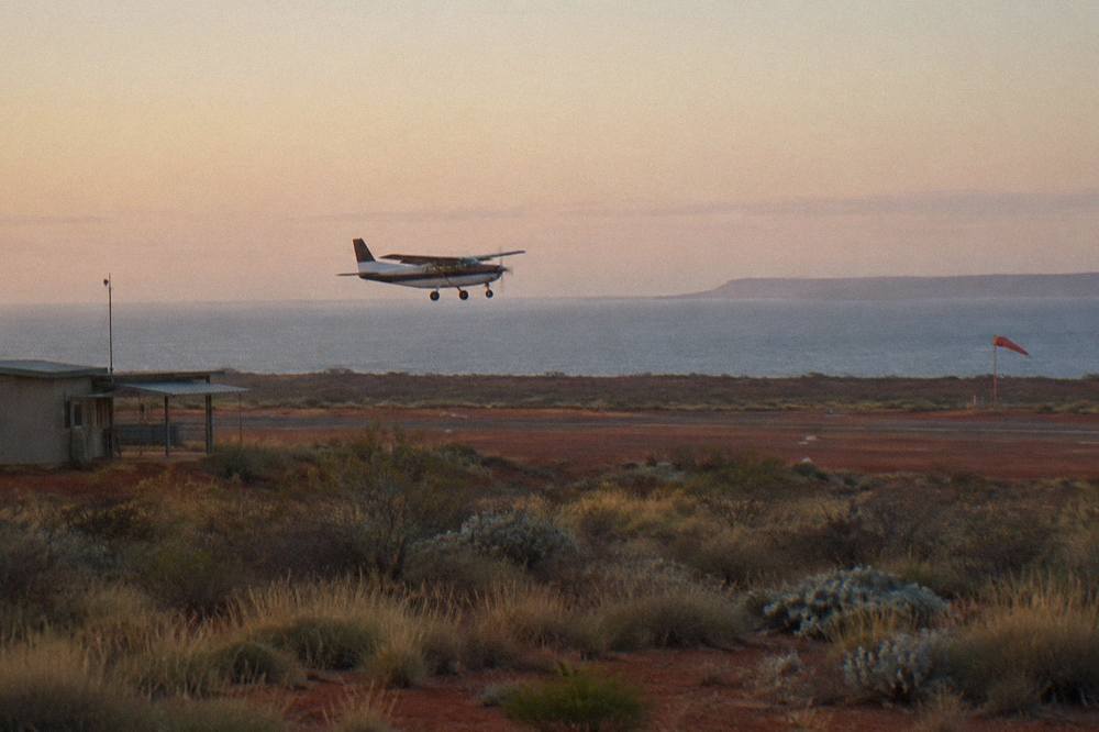 A spotter plane flying low over calm ocean near Ningaloo Reef searching for whale sharks