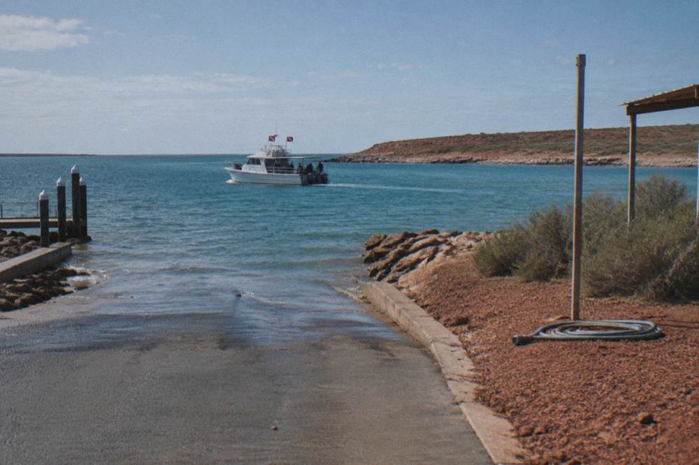 A licensed tour boat with dive flags flying near Ningaloo Reef