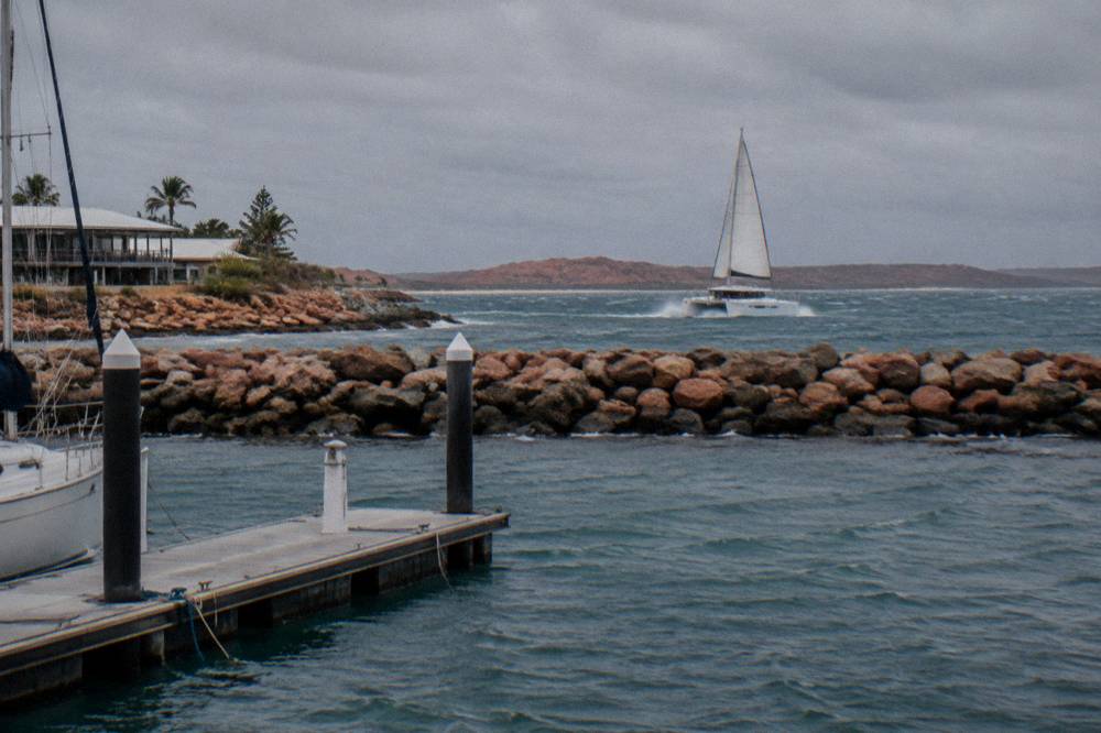 A catamaran tour boat crossing open blue water outside the Ningaloo Reef
