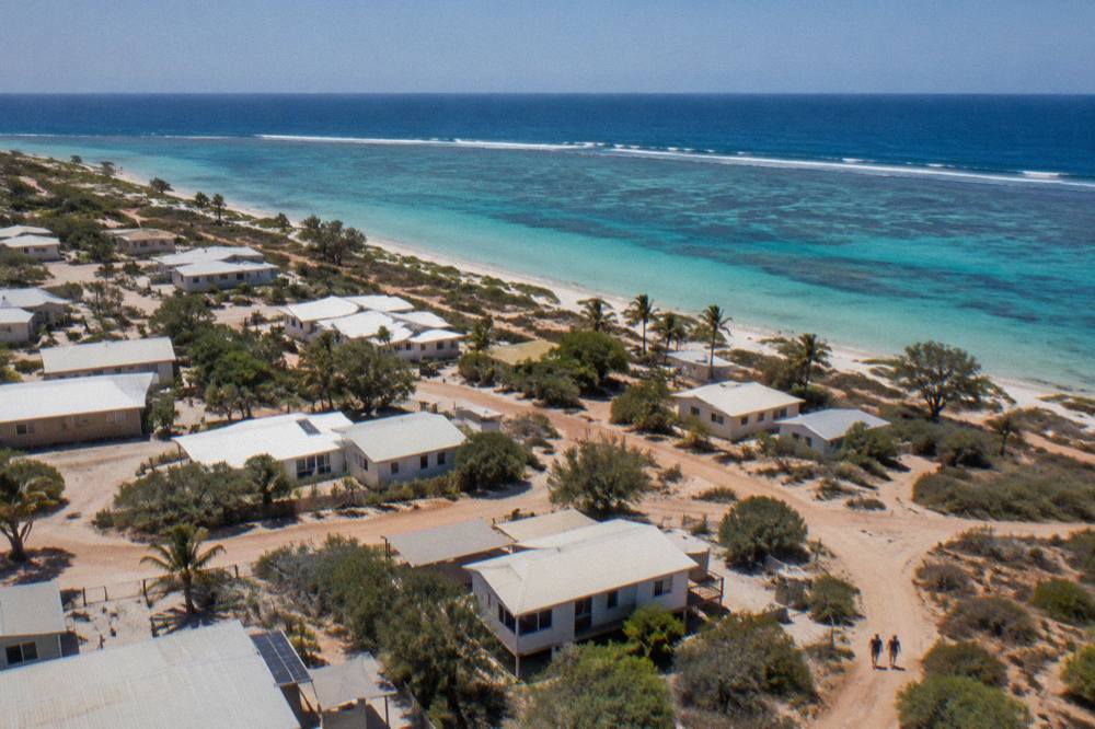 Aerial view of Coral Bay township with the reef line breaking pale water just offshore
