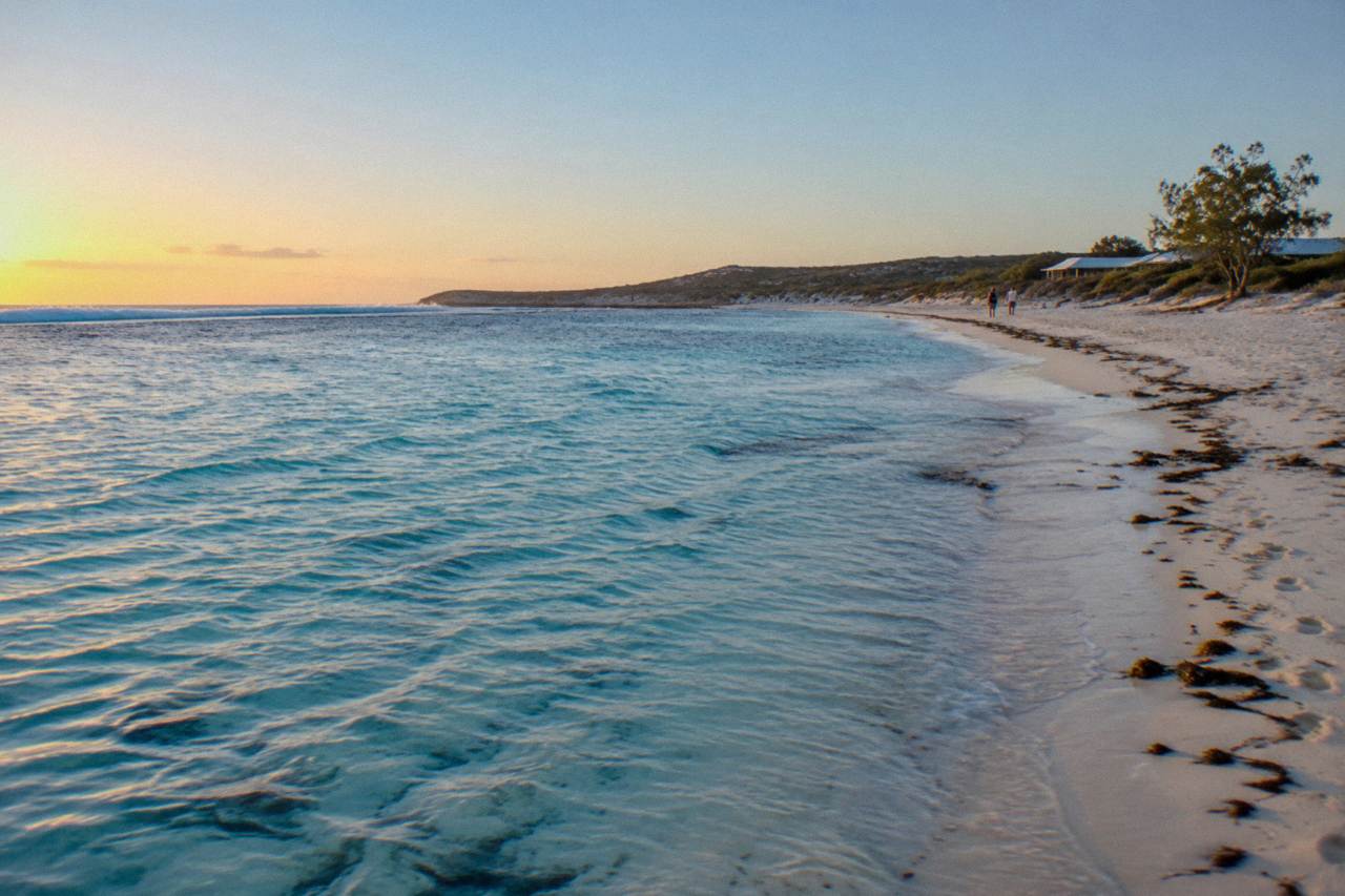 Calm turquoise shallows at Coral Bay with the Ningaloo Reef visible close to the beach