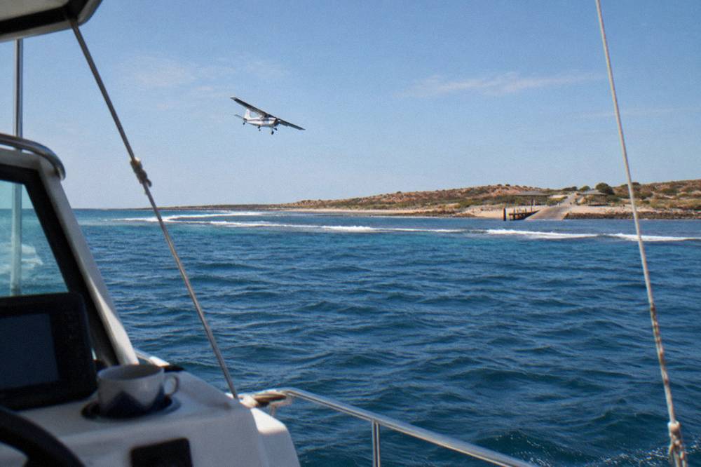 A spotter plane flying low over open ocean swell beyond the Ningaloo Reef crest