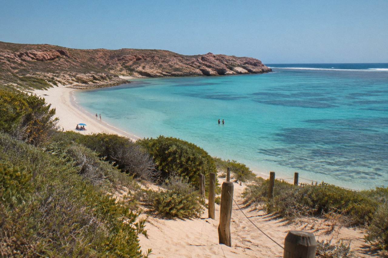 Calm turquoise water along the Ningaloo Reef coastline under a clear sky