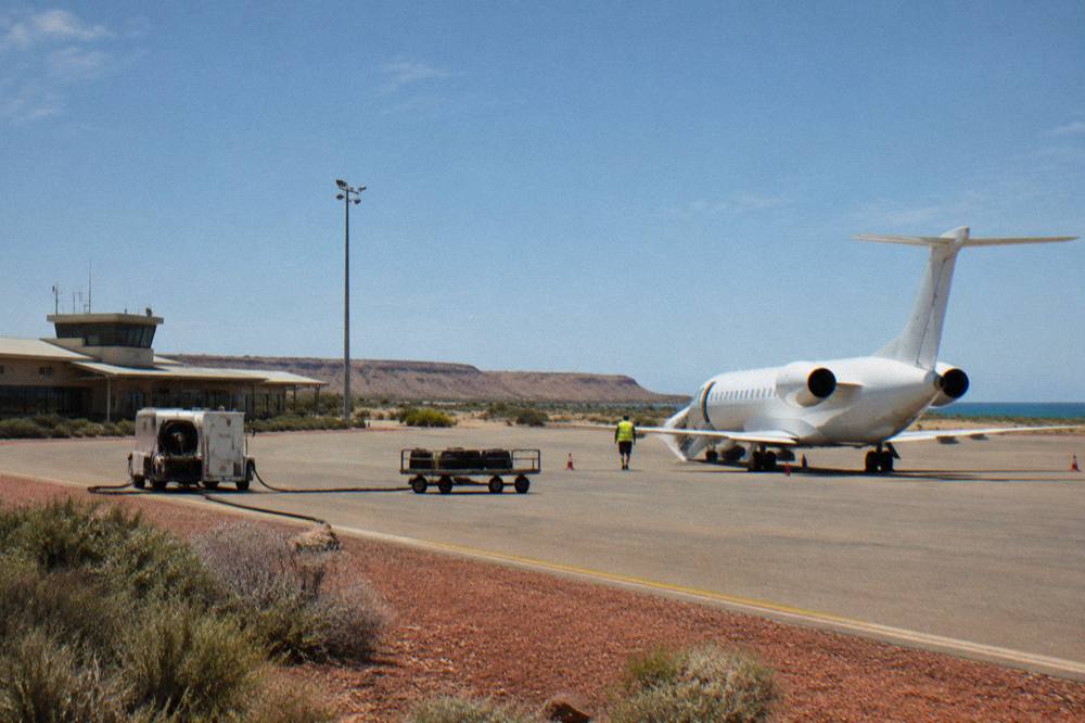 Small regional airport tarmac with a jet aircraft parked under a wide open sky