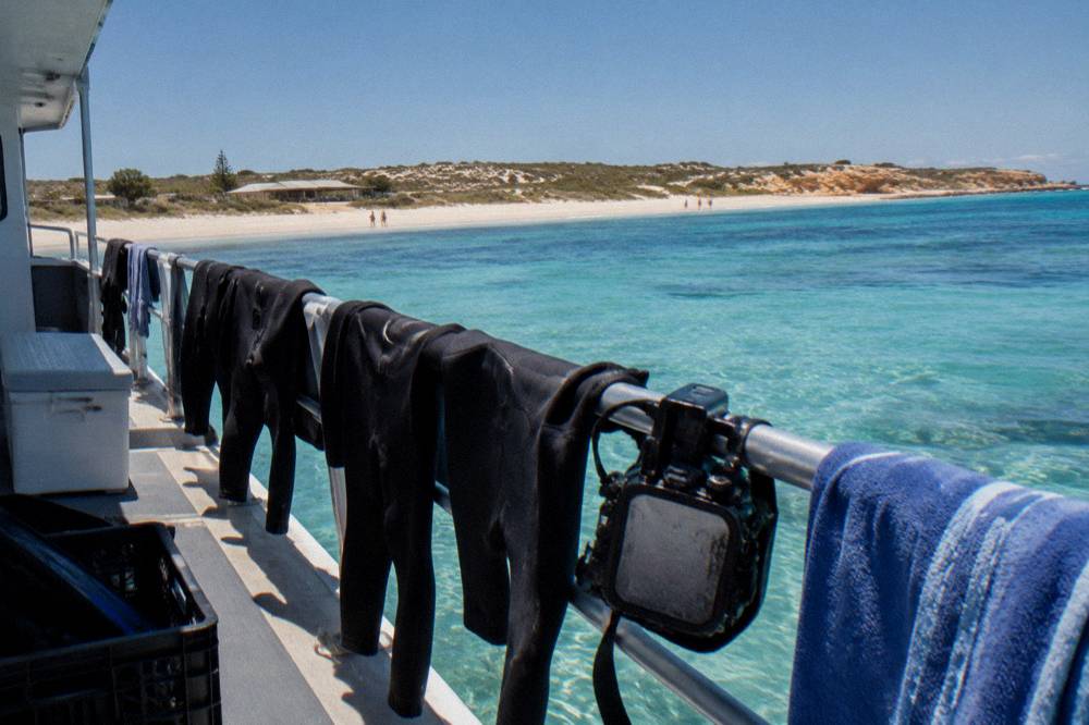 Boat deck with snorkel gear and camera housing drying in the sun