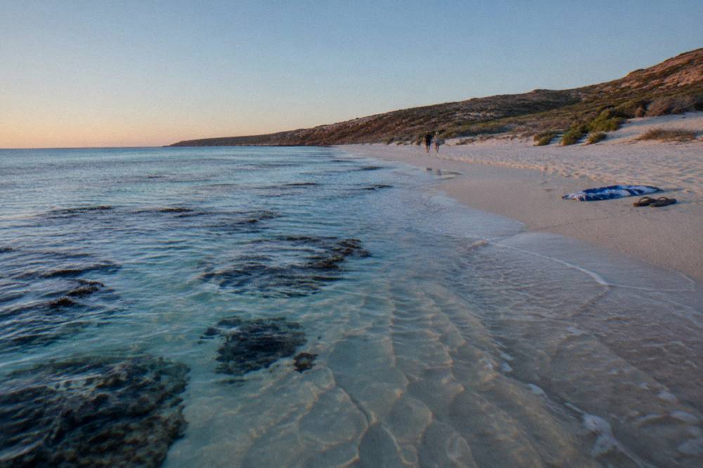 A sheltered sandy beach with reef visible through shallow water
